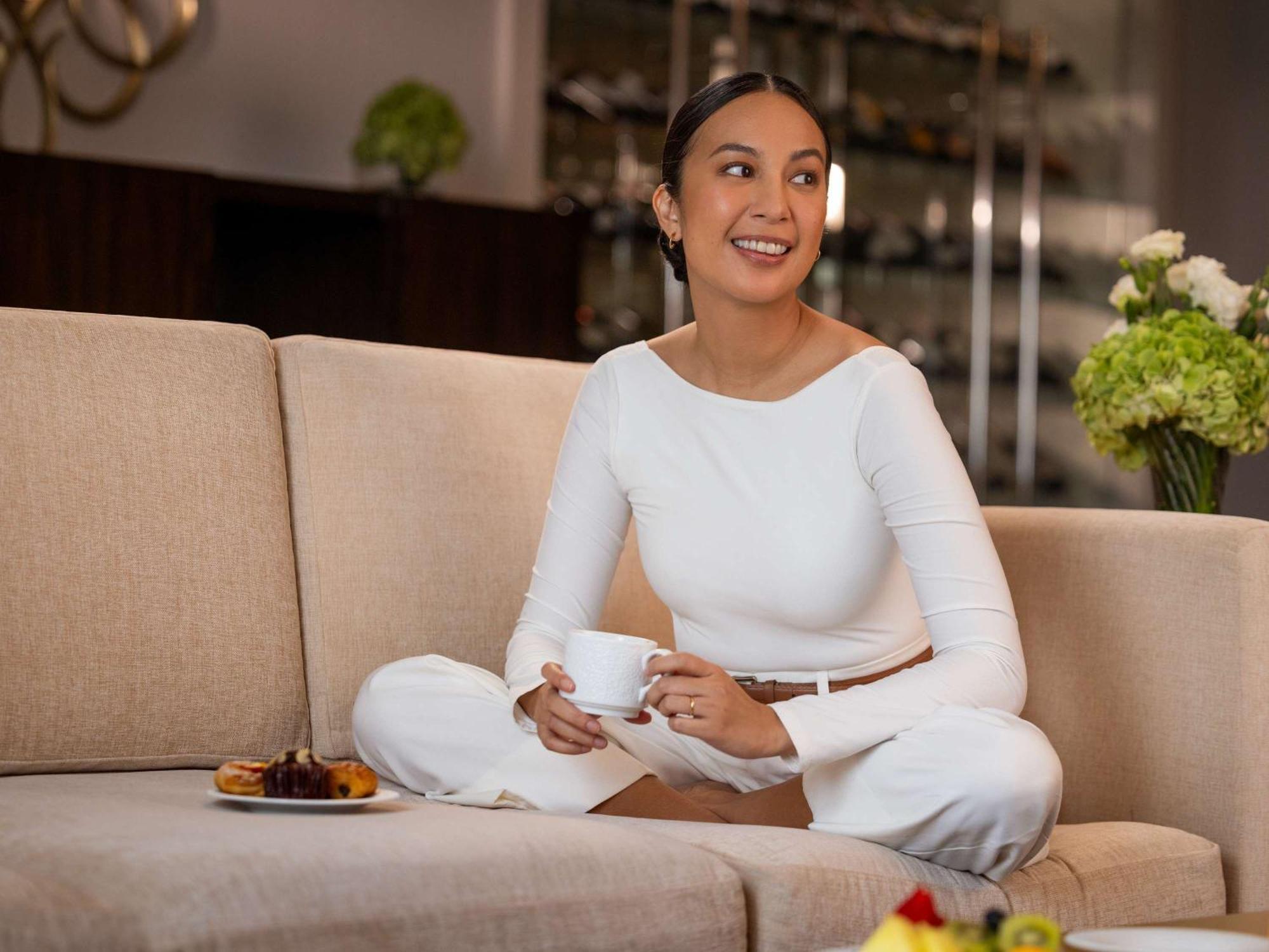 Fairmont Makati Hotel Makati City Exterior photo A woman sitting on a sofa